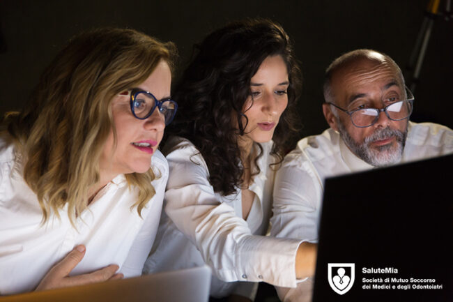 Group of coworkers using laptop in dark office